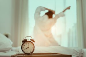 Woman happily getting up when her alarm goes